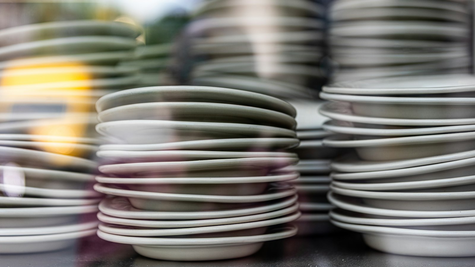 Several stacks of clean white plates ready for service